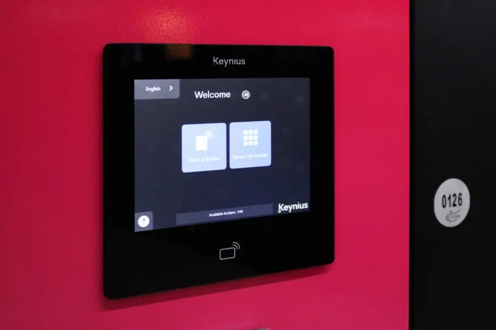 Visitor using a digital smart locker terminal inside a live entertainment attraction